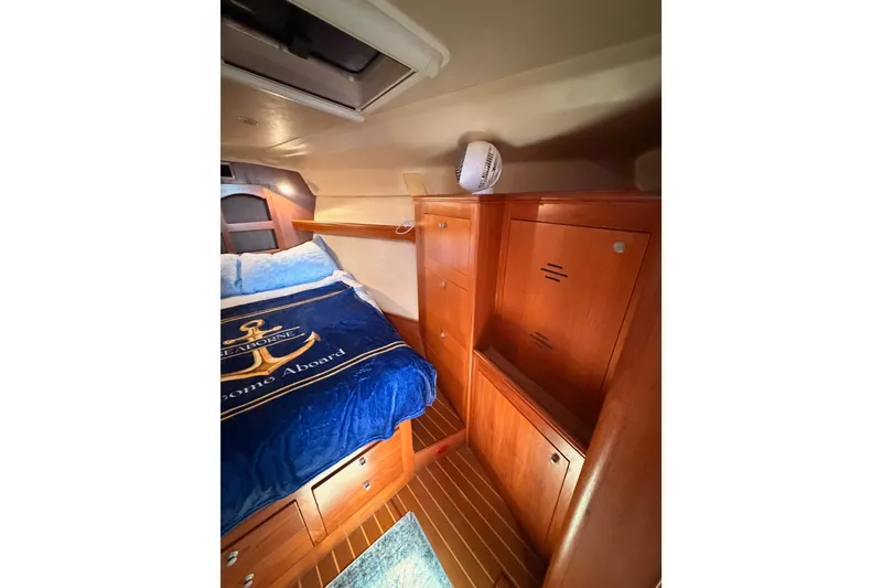 Slide: The Image of Cozy cabin interior of 2002 Hunter 460 yacht with wooden storage and nautical bedding. - 69