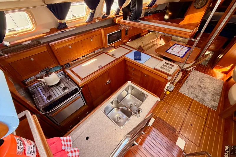 Slide: The Image of Luxurious 2002 Hunter 460 yacht interior with wooden cabinetry and modern kitchen amenities. - 37
