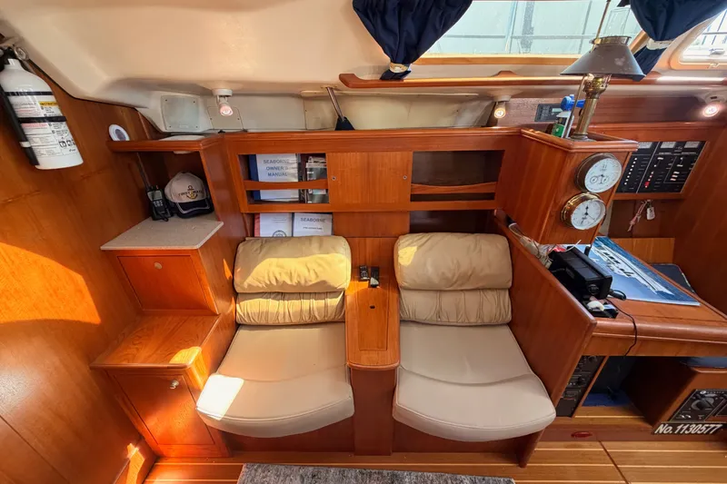 Slide: The Image of Cozy interior of 2002 Hunter 460 yacht with seating, wooden cabinetry, and nautical instruments. - 65