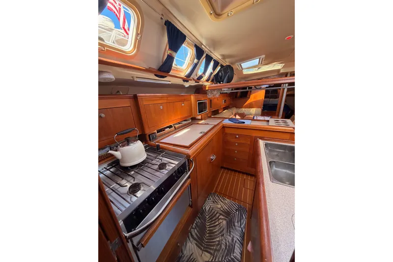 Slide: The Image of Interior of 2002 Hunter 460 yacht kitchen with stove, sink, and wooden cabinetry. - 48