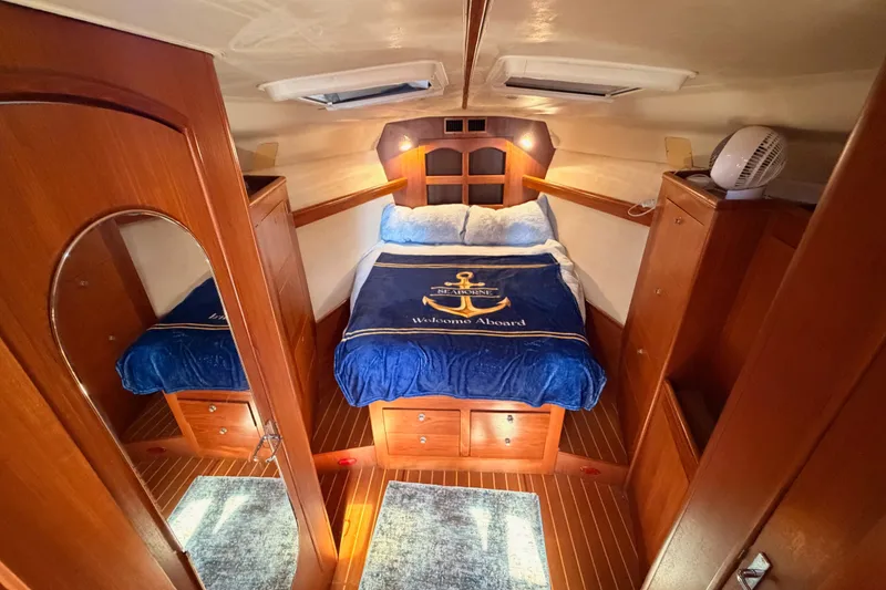 Slide: The Image of Cozy cabin interior of 2002 Hunter 460 yacht with wooden furnishings and nautical bedding. - 67