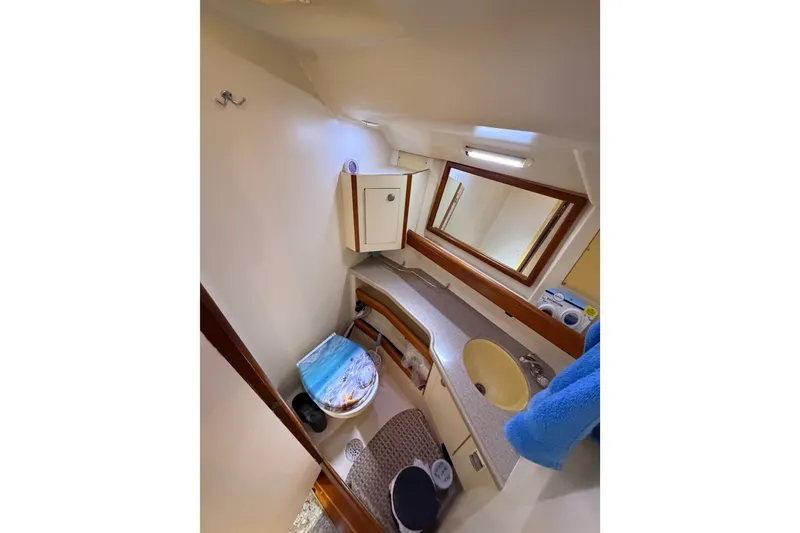 Slide: The Image of Compact bathroom in a 2002 Hunter 460 yacht, featuring sink, mirror, and storage. - 70