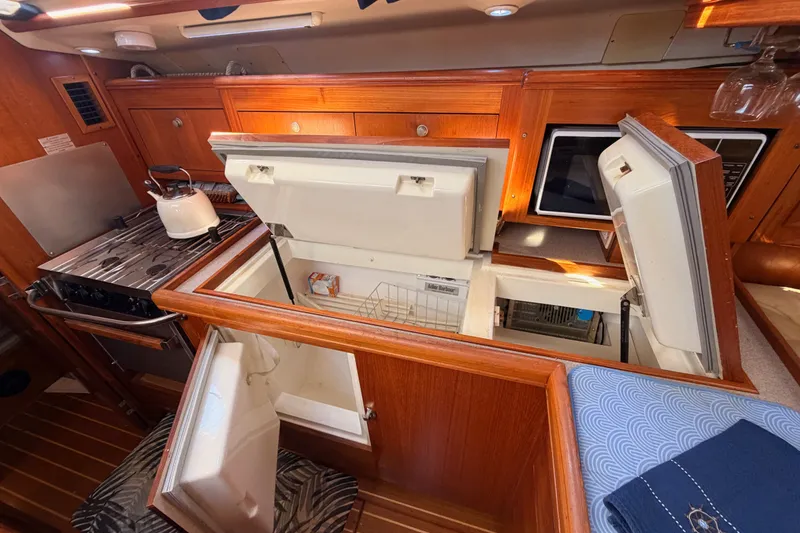 Slide: The Image of Interior of 2002 Hunter 460 yacht kitchen with stove, fridge, and wooden cabinetry. - 41