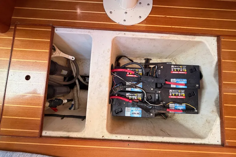 Slide: The Image of Battery compartment of a 2002 Hunter 460 yacht, featuring marine batteries and wiring. - 83