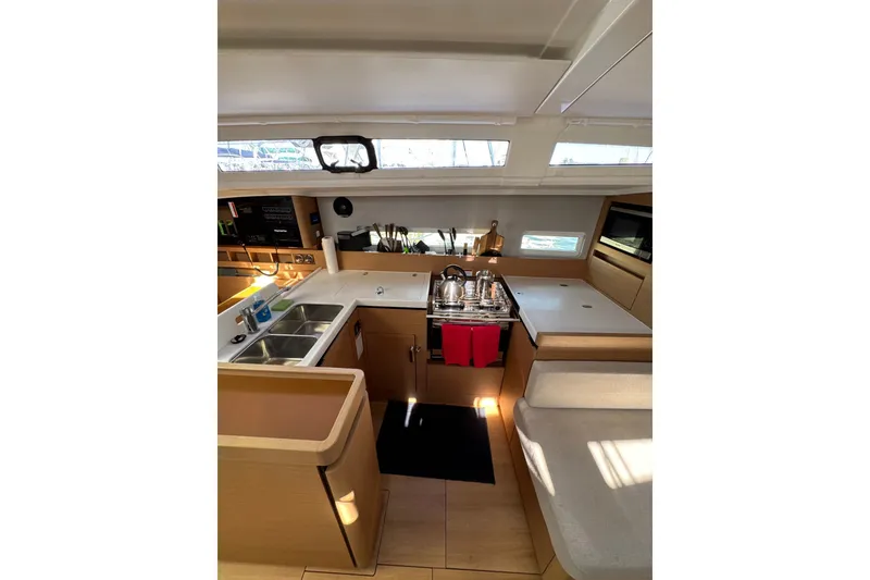 Slide: The Image of Modern kitchen interior of 2022 Jeanneau Sun Odyssey 410 yacht, featuring sleek design and ample lighting. - 14