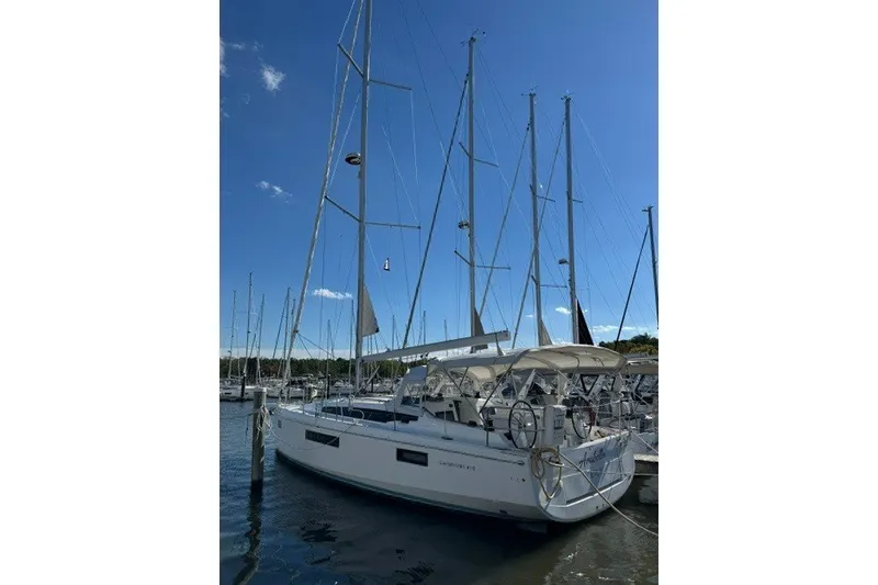 The Image of 2022 Jeanneau Sun Odyssey 410 sailboat docked in marina under clear blue sky. - 0