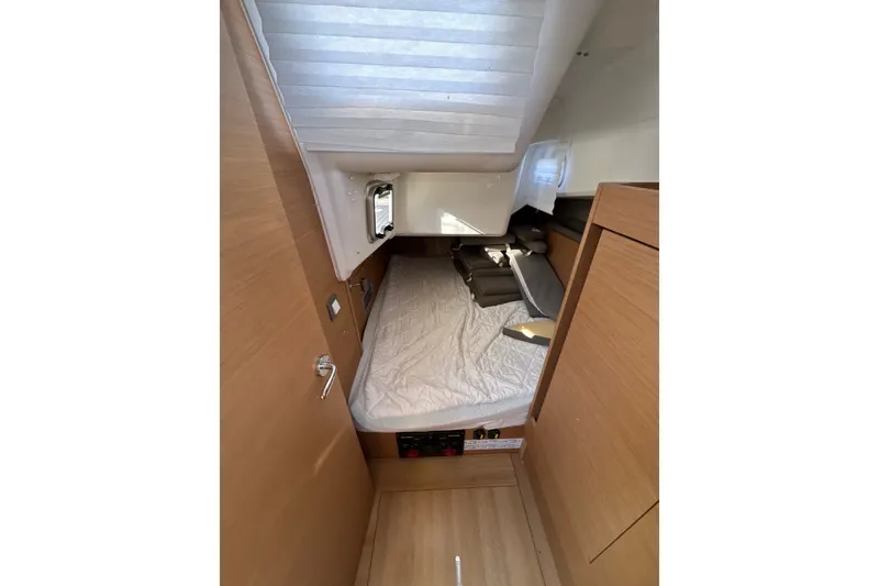 Slide: The Image of Interior cabin of 2022 Jeanneau Sun Odyssey 410 sailboat, featuring a cozy bed and wooden finish. - 18