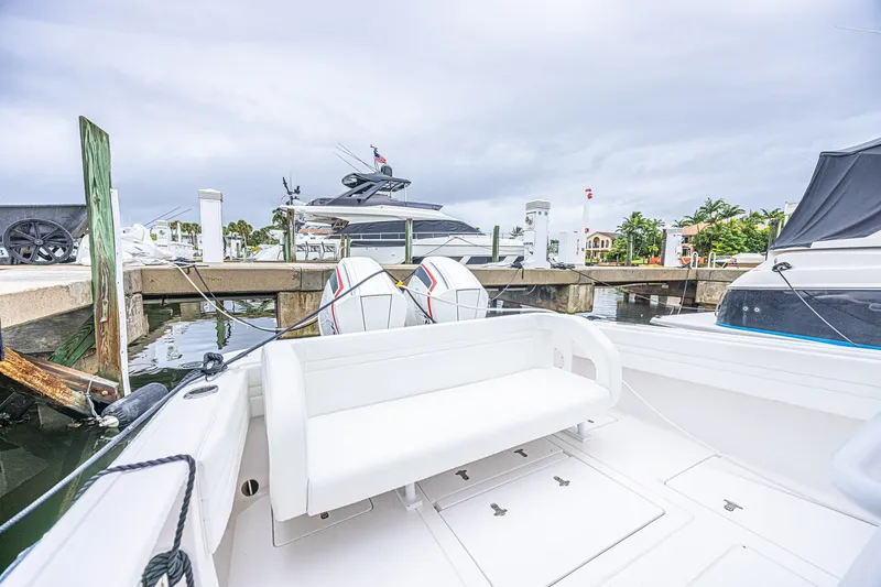 Slide: The Image of 2023 Intrepid 327 Nomad boat docked at marina with twin engines. - 5