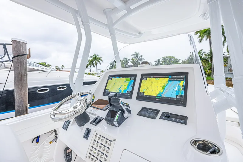 Slide: The Image of 2023 Intrepid 327 Nomad boat dashboard with dual navigation screens and steering wheel. - 11