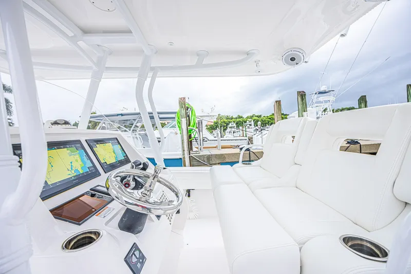 Slide: The Image of 2023 Intrepid 327 Nomad boat interior with modern navigation system and plush seating. - 24
