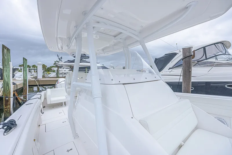 Slide: The Image of 2023 Intrepid 327 Nomad boat docked, showcasing sleek white interior and modern design. - 21