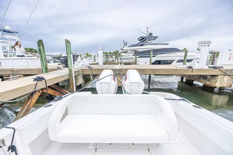 Slide: The Image of 2023 Intrepid 327 Nomad docked at marina, featuring sleek design and powerful engines. - 28
