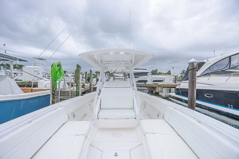 Slide: The Image of 2023 Intrepid 327 Nomad boat docked at marina under cloudy skies. - 16