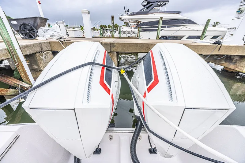Slide: The Image of Twin outboard engines on a 2023 Intrepid 327 Nomad at a marina dock. - 3