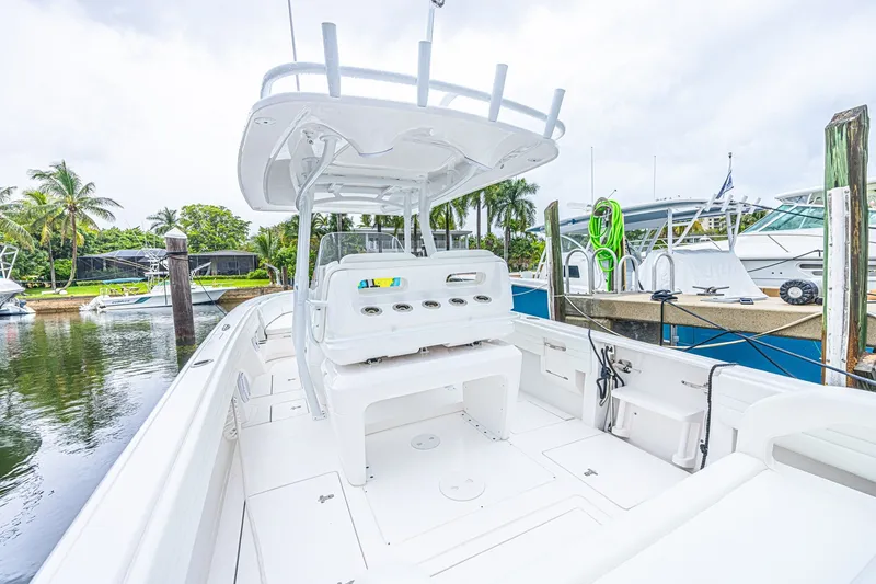 Slide: The Image of 2023 Intrepid 327 Nomad boat docked, featuring spacious white deck and modern design. - 30
