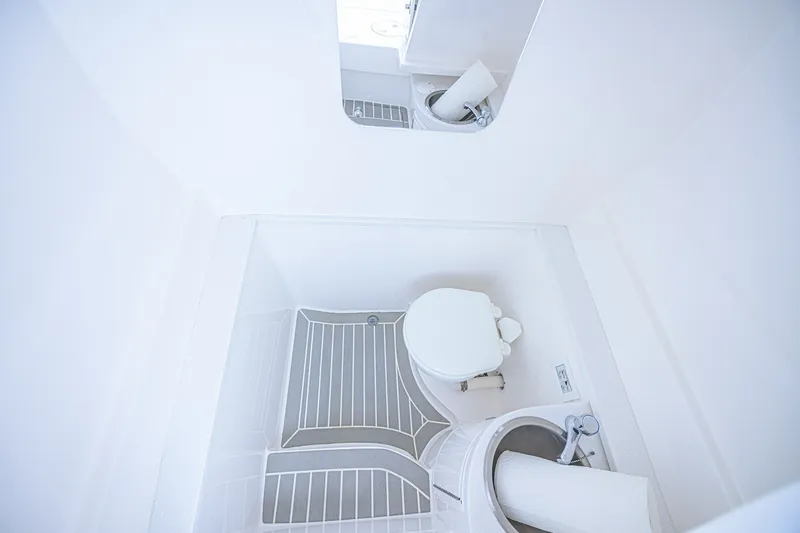 Slide: The Image of 2023 Intrepid 327 Nomad boat bathroom with compact toilet and sink. - 33