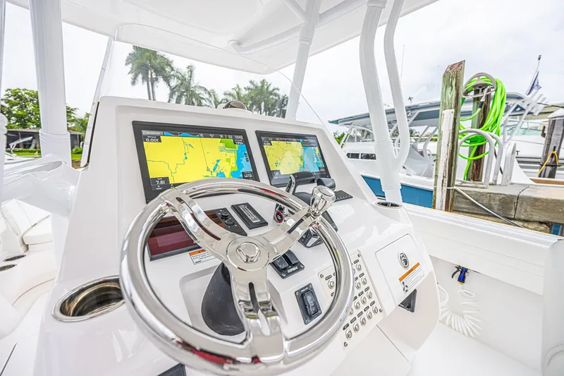 Slide: The Image of Steering console of 2023 Intrepid 327 Nomad boat with navigation screens and controls. - 13
