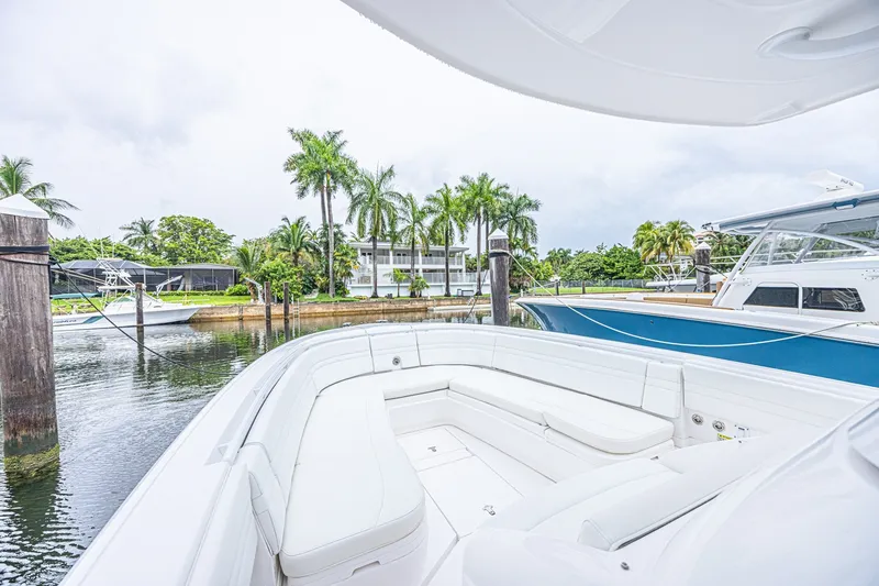 Slide: The Image of Luxurious 2023 Intrepid 327 Nomad boat docked, featuring spacious seating and scenic waterfront view. - 26