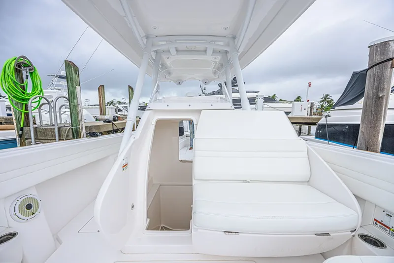 Slide: The Image of 2023 Intrepid 327 Nomad boat interior with white seating and storage compartment. - 34