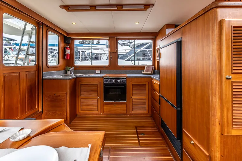 Slide: The Image of Interior of 2010 North Pacific 39 Pilothouse yacht with wooden cabinetry and modern appliances. - 27