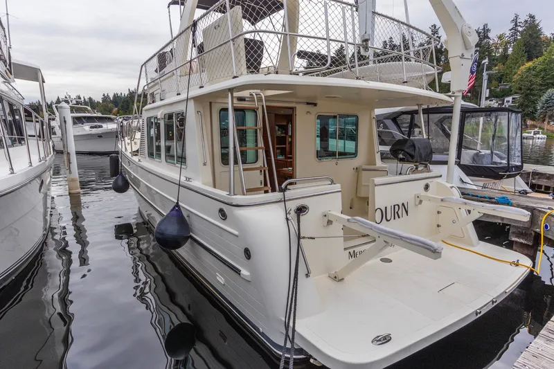 Slide: The Image of 2010 North Pacific 39 Pilothouse yacht docked at marina, showcasing rear deck and exterior design. - 29
