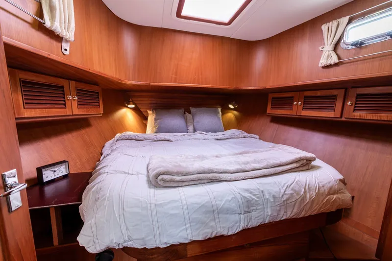 Slide: The Image of Cozy bedroom in 2010 North Pacific 39 Pilothouse yacht with wood paneling and soft lighting. - 17