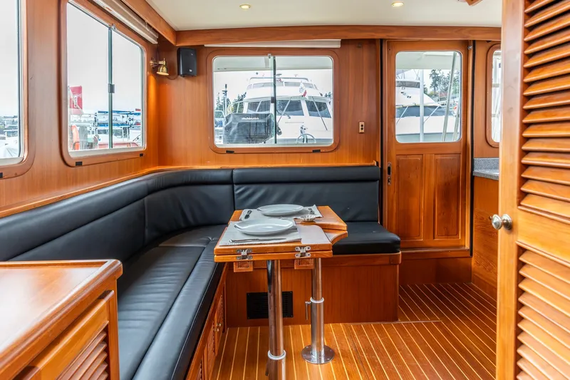 Slide: The Image of Interior of 2010 North Pacific 39 Pilothouse with wood finish and dining area. - 25