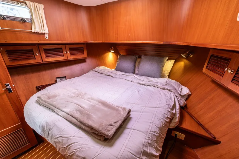 Slide: The Image of Cozy cabin interior of 2010 North Pacific 39 Pilothouse with wooden finish and comfortable bedding. - 19