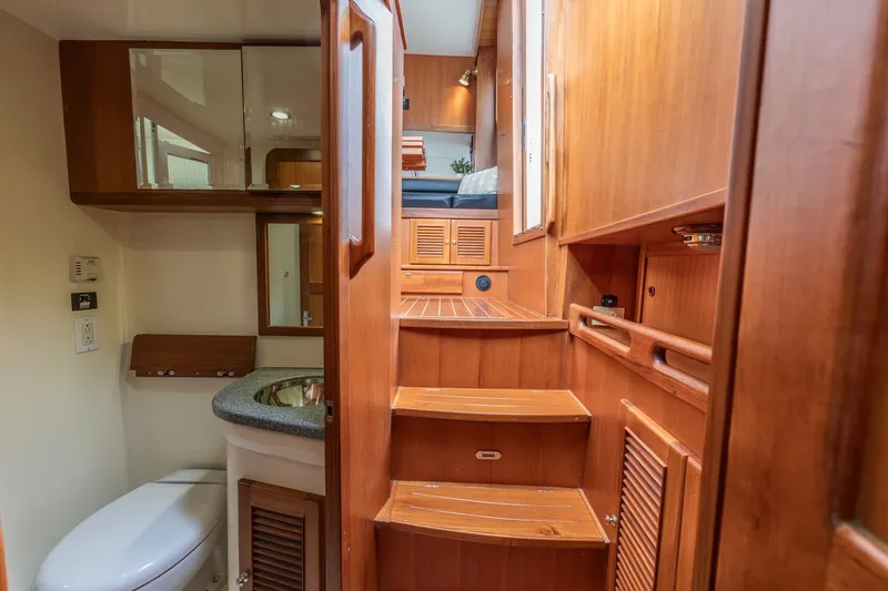 Slide: The Image of Interior of 2010 North Pacific 39 Pilothouse, featuring wooden stairs and compact bathroom. - 20