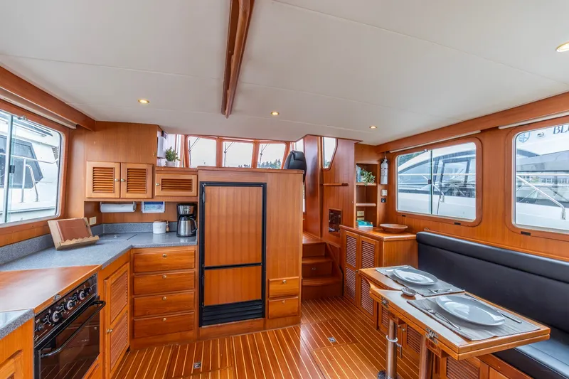 Slide: The Image of Interior of 2010 North Pacific 39 Pilothouse yacht with wood finish and dining area. - 28