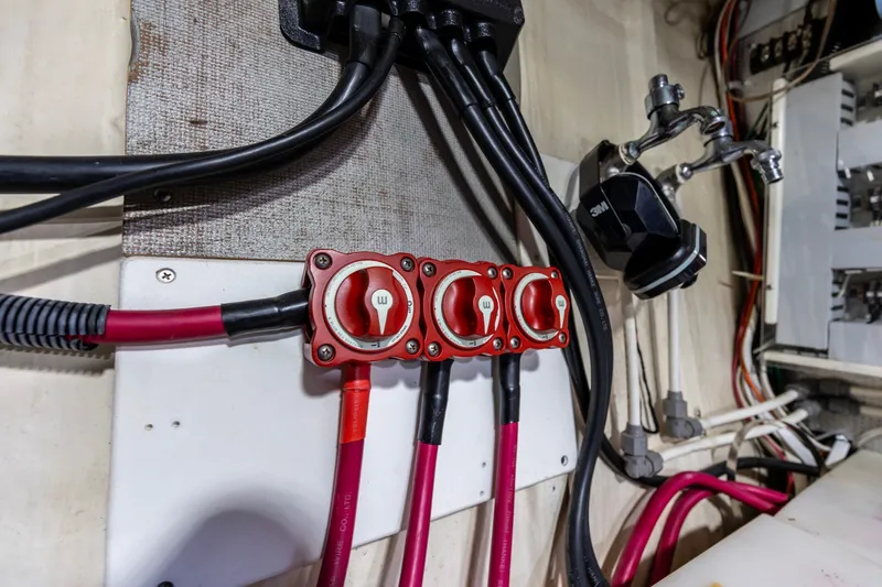 Slide: The Image of Electrical panel with red switches and cables on a 2010 North Pacific 39 Pilothouse boat. - 44