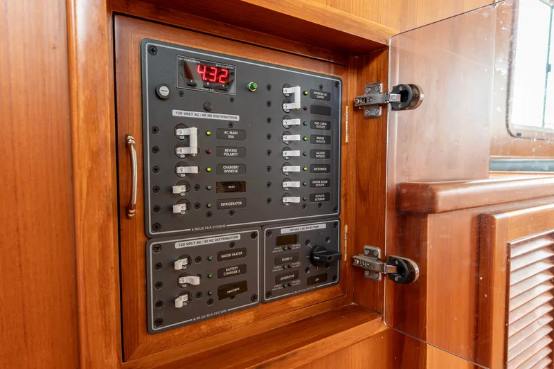 Slide: The Image of Electrical panel inside 2010 North Pacific 39 Pilothouse boat, featuring various switches and controls. - 24