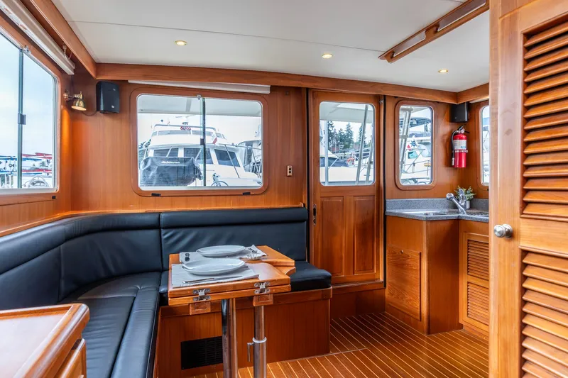Slide: The Image of Interior of 2010 North Pacific 39 Pilothouse with wood finish and dining area. - 26