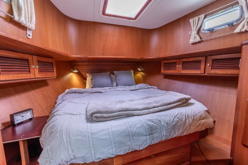 Slide: The Image of Cozy cabin interior of 2010 North Pacific 39 Pilothouse with wooden finish and comfortable bedding. - 18
