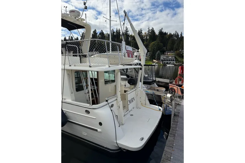 Slide: The Image of 2010 North Pacific 39 Pilothouse docked, showcasing rear deck and marina setting. - 49