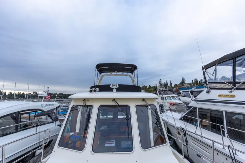 Slide: The Image of 2010 North Pacific 39 Pilothouse yacht docked among other boats under cloudy skies. - 42
