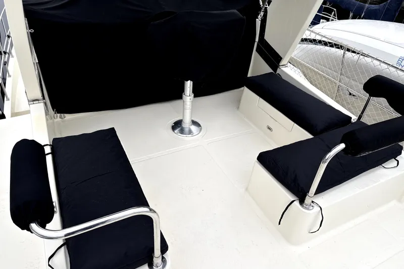 Slide: The Image of 2010 North Pacific 39 Pilothouse seating area with black cushions and metal railings. - 38