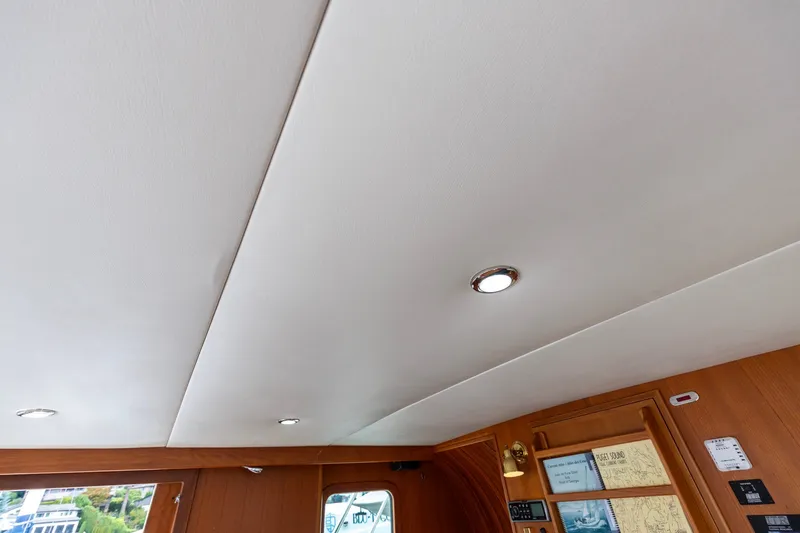 Slide: The Image of Ceiling view of 2010 North Pacific 39 Pilothouse with recessed lighting and wooden interior details. - 21