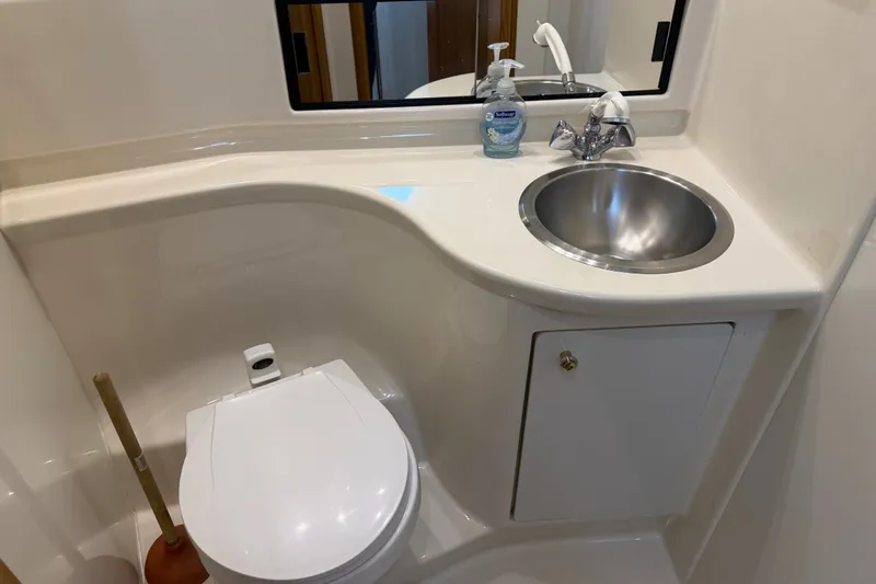 Slide: The Image of Compact bathroom in 2000 Bayliner 3988 Command Bridge Motoryacht with sink and toilet. - 32