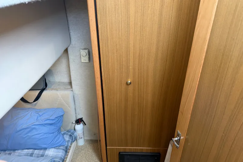 Slide: The Image of Interior cabin of 2000 Bayliner 3988 Command Bridge Motoryacht with bedding and fire extinguisher. - 28