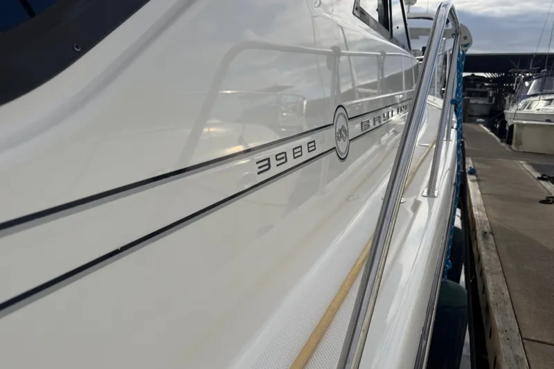 Slide: The Image of 2000 Bayliner 3988 Command Bridge Motoryacht docked, showcasing sleek design and branding. - 52