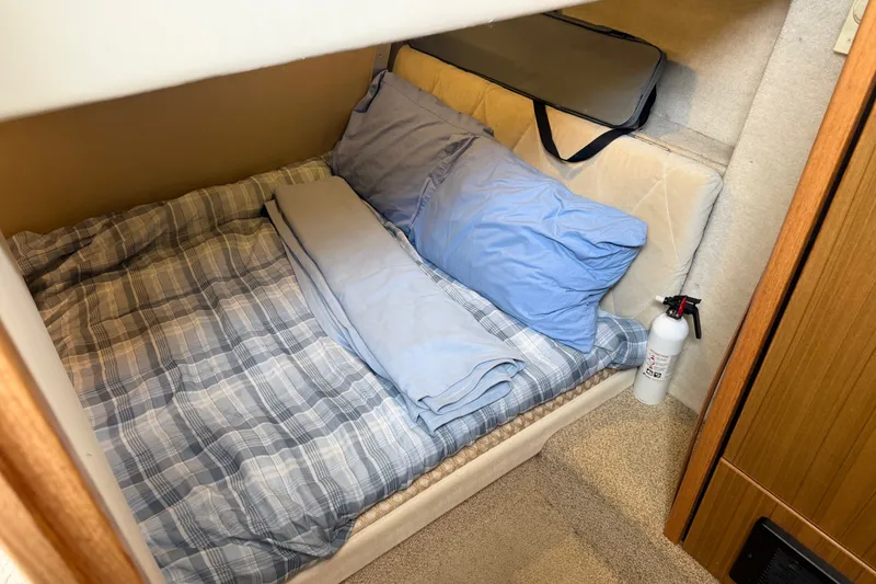 Slide: The Image of Cozy sleeping area in 2000 Bayliner 3988 Command Bridge Motoryacht with plaid bedding and fire extinguisher. - 29