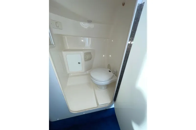 Slide: The Image of Interior view of 2015 Sea Ray SLX 350 boat bathroom with toilet and storage. - 21