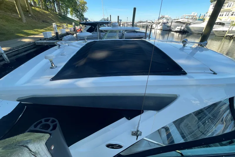 Slide: The Image of 2015 Sea Ray SLX 350 boat docked at a marina, featuring sleek design and covered deck. - 5