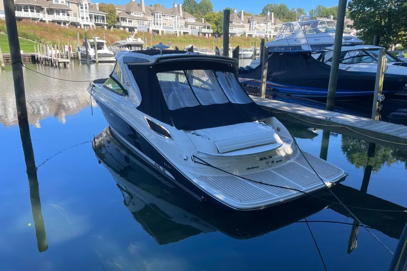 Slide: The Image of 2015 Sea Ray SLX 350 boat docked in a serene marina setting. - 2