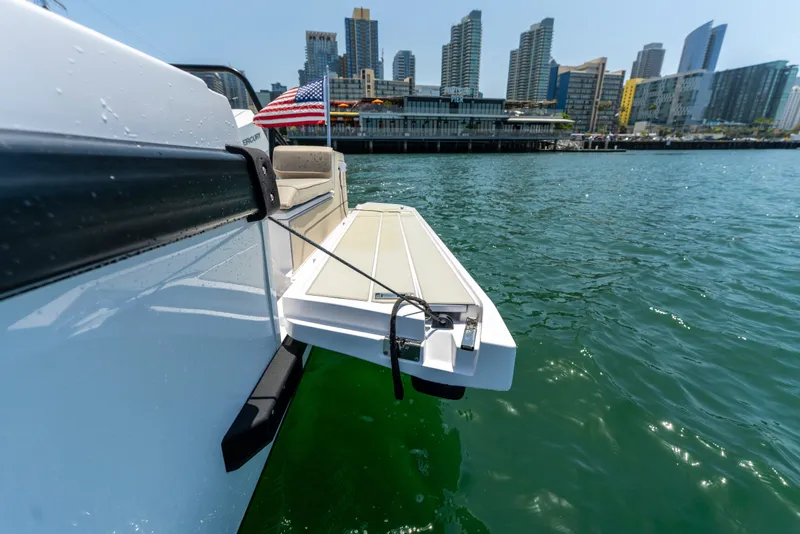 Slide: The Image of 2027 Axopar 38 Cross Cabin boat with extended platform, city skyline in background. - 19