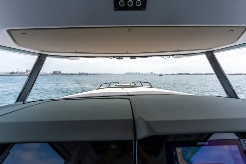 Slide: The Image of Interior view from 2027 Axopar 38 Cross Cabin, overlooking calm waters and distant cityscape. - 26
