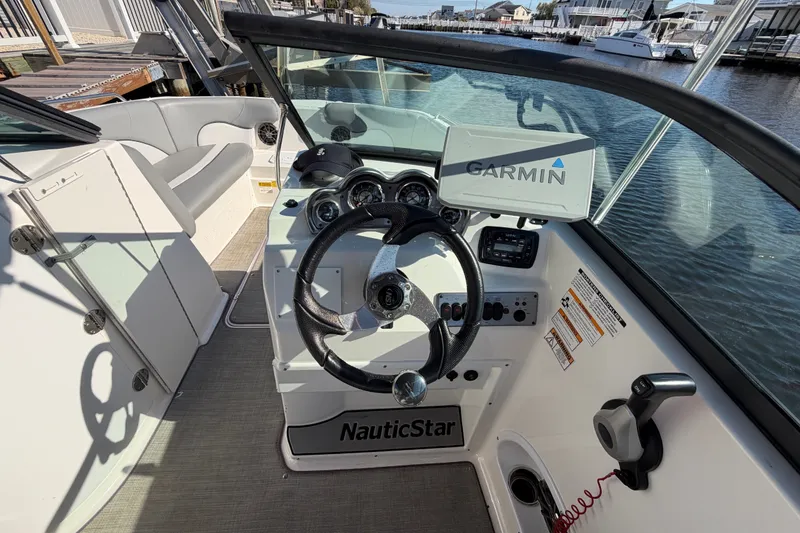 Slide: The Image of 2021 NauticStar 223 DC boat cockpit with Garmin navigation system and steering wheel. - 14