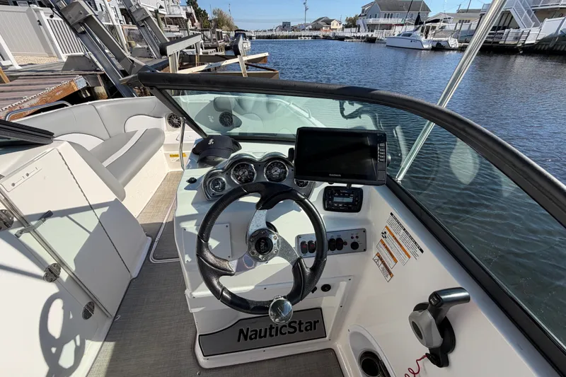 Slide: The Image of 2021 NauticStar 223 DC boat cockpit with steering wheel and navigation system. - 15