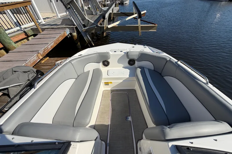 Slide: The Image of 2021 NauticStar 223 DC boat interior with gray seating, docked by the water. - 19